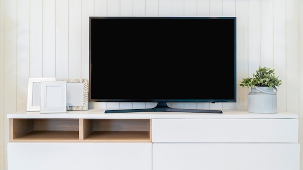 TV con maqueta de pantalla en blanco. Televisión en el mueble en la moderna sala de estar.