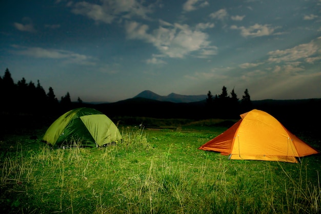 Twp beleuchtete Campingzelte auf einem Feld in der Nacht