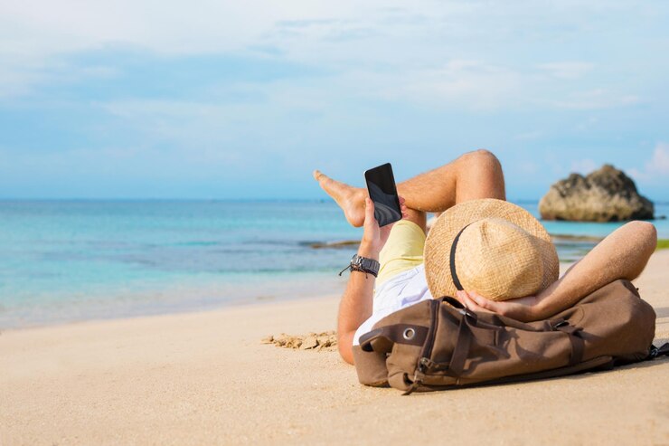 Foto typ mit smartphone am strand liegen