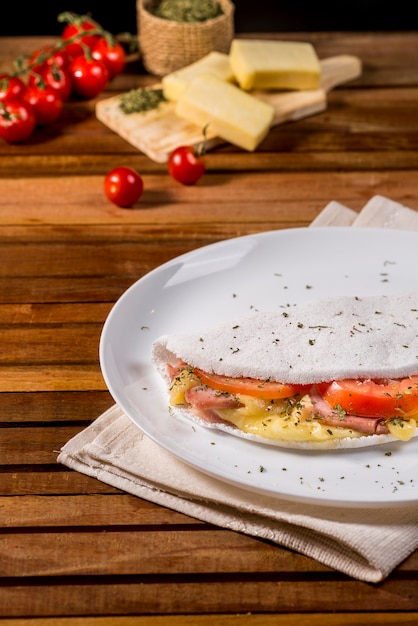 Typisch brasilianisches Tapioka-Essen mit Käse-, Schinken-, Tomaten- und Oregano-Füllung.