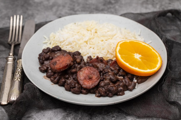 Typische brasilianische Lebensmittelbohnen mit Würstchen und Reis Feijoada auf weißem Teller