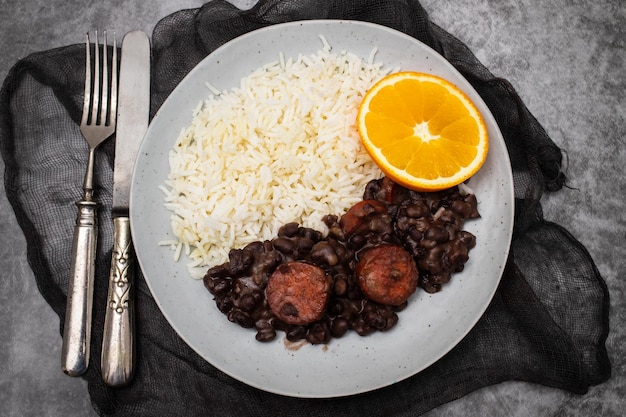 Typische brasilianische Lebensmittelbohnen mit Würstchen und Reis Feijoada auf weißem Teller