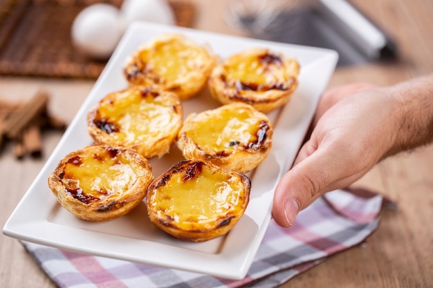 Typische portugiesische Puddingkuchen. traditionelles portugiesisches Gebäck. Halten von einem Koch.