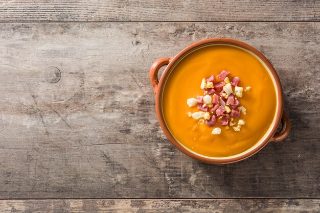 Typische spanische Salmorejo-Creme mit Schinken und Ei auf Holztisch Draufsicht Copyspace