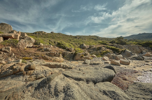 Typischer Blick auf die mediterranen Felsen, die sich zu den mit Vegetation bedeckten Hügeln erheben