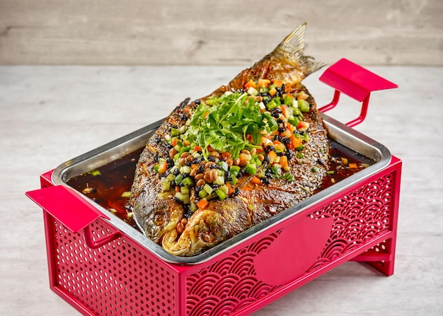 Typischer Fisch Fermentierte schwarze Bohne in einem Gericht isoliert auf Eintopf auf Mattenseitenansicht auf grauem Hintergrund