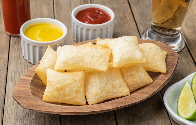 Typisches brasilianisches Fingerfood in Pastelltönen über Holztisch