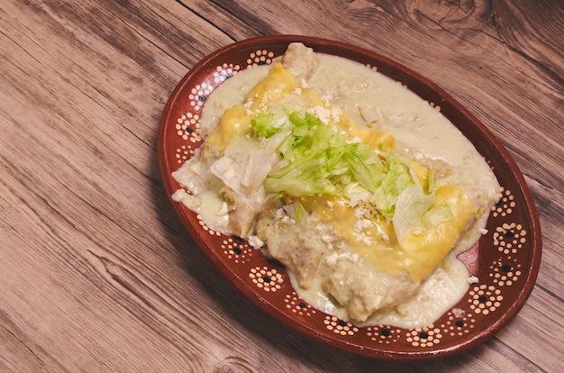 Typisches mexikanisches Essen Grüne Enchiladas auf Holztisch