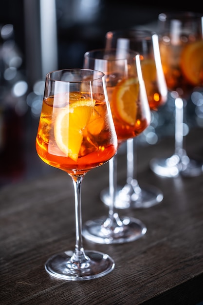 Typisches sommerliches Sektgetränk Aperol Spritz serviert in Weingläsern mit Aperol, Prosecco, Soda und einer Orangenscheibe.