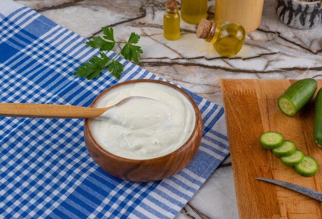 Foto tzatziki - salsa de yogur griego en un recipiente sobre fondo de mármol. (nombre turco cacik)
