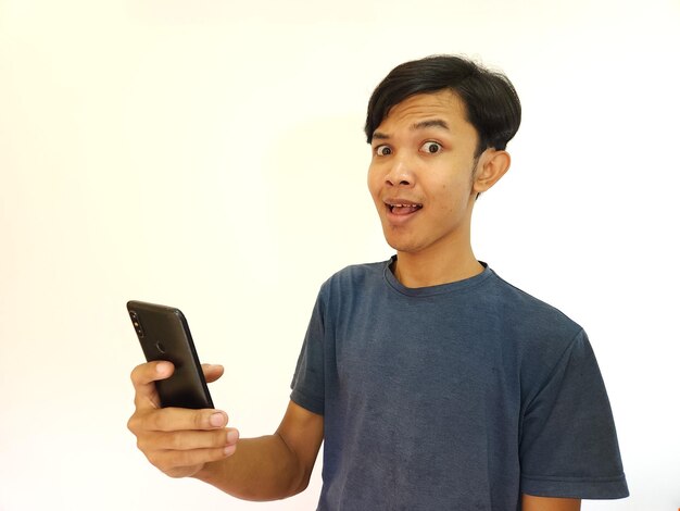 Uau e cara surpresa homem asiático usa smartphone com espaço de cópia de anúncio