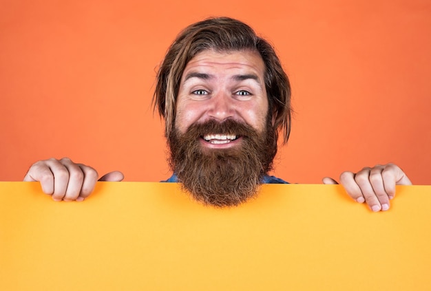 Uau emoções humanas cara não barbeado com cabelo comprido arrumado barbearia e cabeleireiro beleza masculina e moda homem barbudo feliz hipster caucasiano brutal segure papel merda cópia espaço