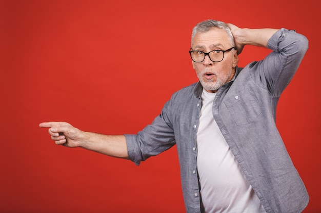 Uau! inacreditável! com idade chocado sênior homem de óculos, apresentando-se com a mão e apontando com o dedo.