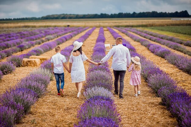 UCRANIA 04 DE JULIO DE 2021 Familia feliz caminando en el floreciente campo de lavanda en Ucrania