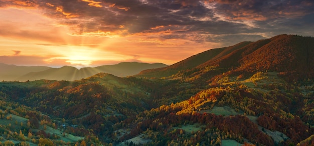 Ucrania Cálido otoño en un pueblo Pintorescos bosques de hayas, abedules y pinos y casas Hutsul contra el telón de fondo de la cresta Synevyr Pass son muy hermosas con colores brillantes después de un buen día