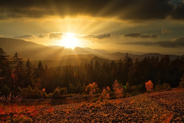 Foto ucrania gran escena muy hermosa puesta de sol de invierno con montañas y nubes los rayos del sol atravesando el espesor de las nubes pintan todo a su alrededor con luz mágica cárpatos