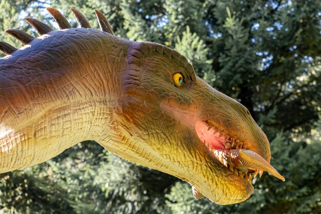 Ucrânia, Khmelnitsky, outubro de 2021. Modelo de um dinossauro barionix com peixes na boca no parque em tempo ensolarado de perto