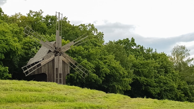 Ucrania, Kiev - 11 de junio de 2020. Antiguos molinos de viento de madera ucranianos del siglo XIX. Paisaje al aire libre de verano. Museo al aire libre de arquitectura y vida popular, Pirogovo, Ucrania. Turismo y viajes.