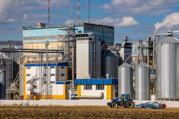 Ucrânia Kyiv, 20 de agosto de 2022, o trator New Holland trabalha perto de um silo agrícola