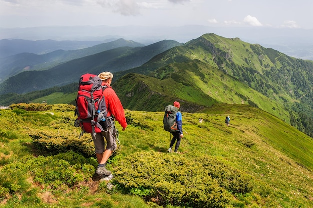 Ucrânia. Montanhas carpathian. Um grupo de turistas com mochilas grandes