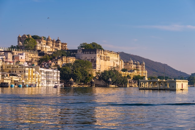 Udaipur-Stadtbild mit buntem Himmel bei Sonnenuntergang. Der majestätische Stadtpalast auf See Pichola, Reiseziel in Rajasthan, Indien