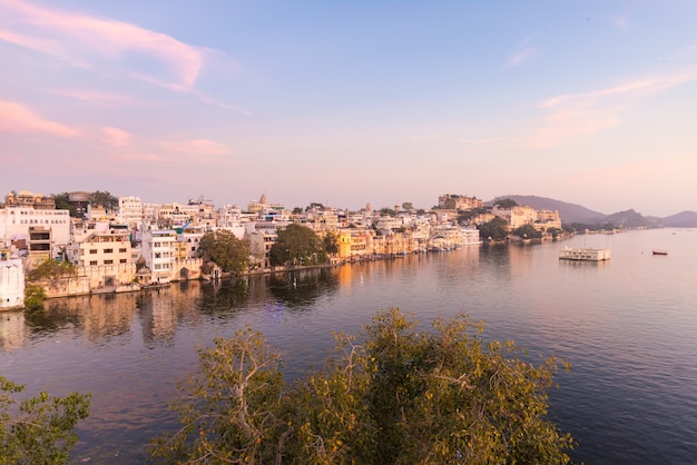 Udaipur-Stadtbild mit buntem Himmel bei Sonnenuntergang. Der majestätische Stadtpalast auf See Pichola, Reiseziel in Rajasthan, Indien