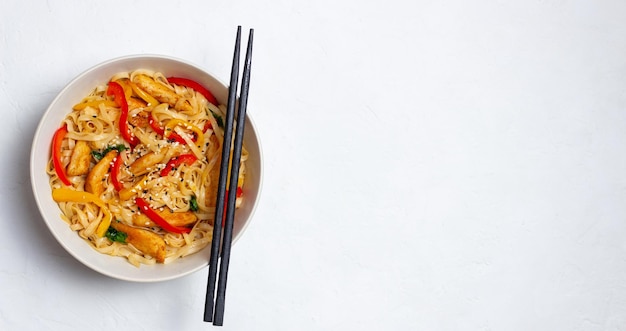 Udon-Nudeln mit Huhn, Pfeffer und Sesam. Chinesisches Essen.