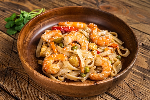 Udon refogado com macarrão de camarão em uma tigela de madeira