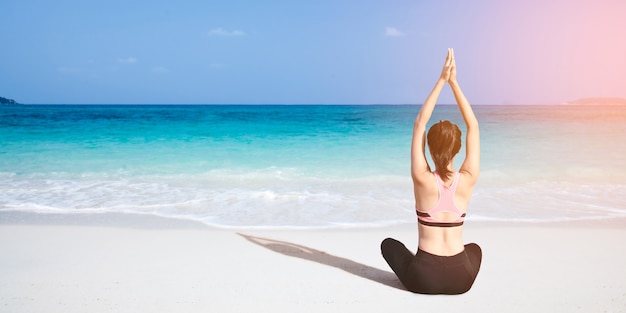 Foto Übendes yoga der kaukasischen frau an der küste