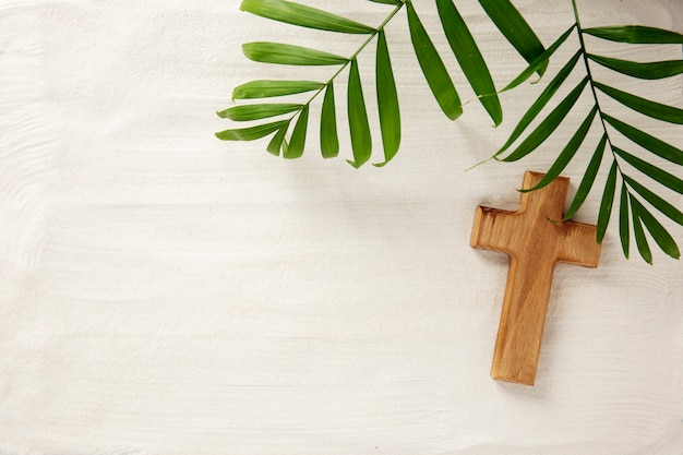 Über Holzkreuz und Blätter auf Sand