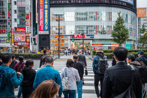 Foto Überfüllte menschen gehen und einkaufen auf einer straße in der stadt shinjuku