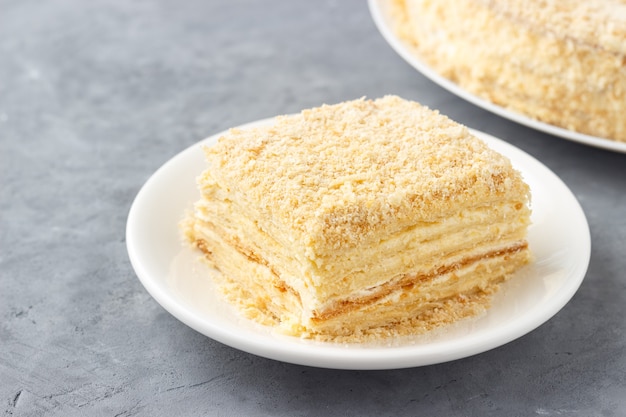 Foto Überlagerter kuchen mit sahne napoleon millefeuille vanillescheibe auf einem weißen teller.