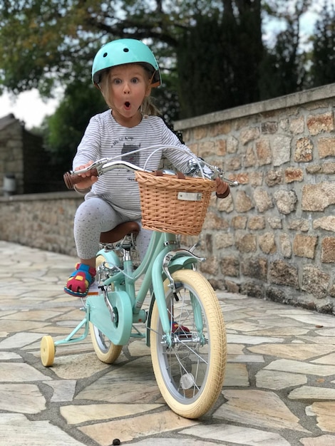 Foto Überraschendes mädchen mit helm auf dem fahrrad