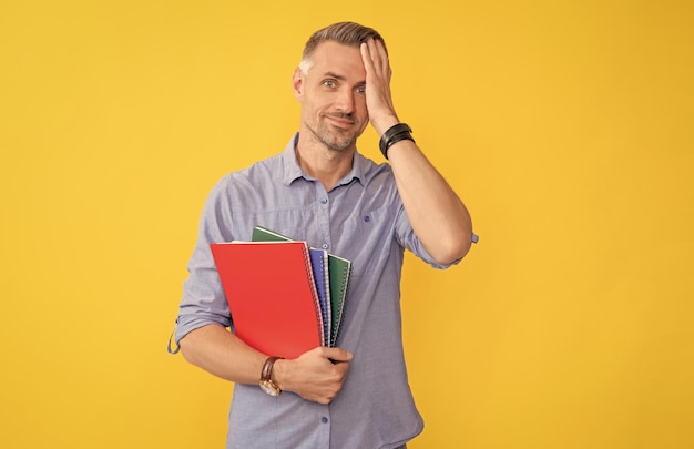 Überraschter Mann hält Schulheft oder Planeruniversität