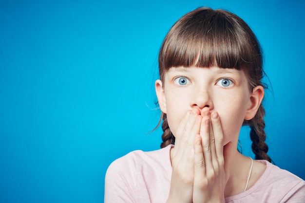 Foto Überraschtes erstauntes überwältigtes mädchen, das ihren mund mit emotionaler reaktion der hände bedeckt