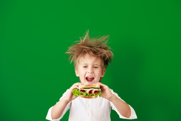 Foto Überraschtes kind gegen grüne tafel im unterricht