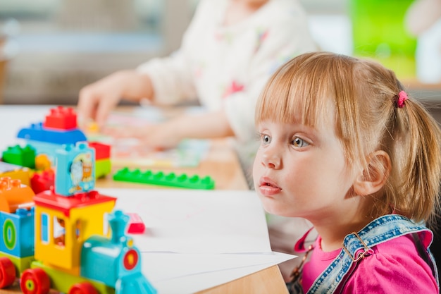 Foto Überraschtes kleinkind mädchen mit spielzeug