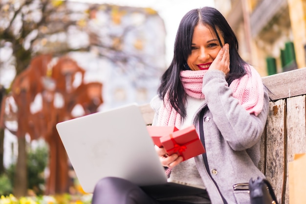 Überraschungsgeschenk, porträt eines sehr aufgeregten mädchens, das das geschenk des freundes in einem videoanruf mit dem computer öffnet, getrennt durch entfernung