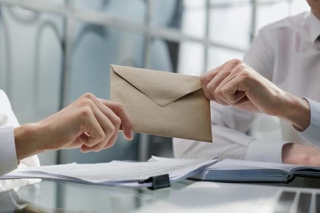 Foto Übertragen sie den umschlag mit geld im büro von hand zu hand