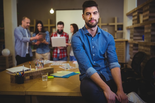 Überzeugter Geschäftsmann, der auf Tabelle im Büro sitzt