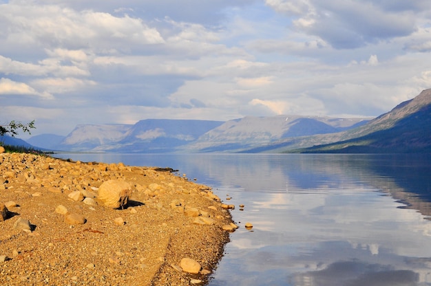 Ufer der Seen auf dem Putorana-Plateau Sommerliche Wasserlandschaft mit Steinen am Ufer im Vordergrund