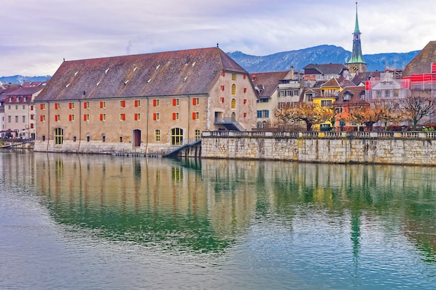 Foto uferpromenade mit landhaus und uhrturm in solothurn. solothurn ist die hauptstadt des kantons solothurn in der schweiz. es liegt am ufer der aare und am fusse des weissensteinjuras