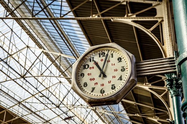 Uhr im Bahnhof, große alte Vintage-Uhr hängen mit Dach des Bahnhofs