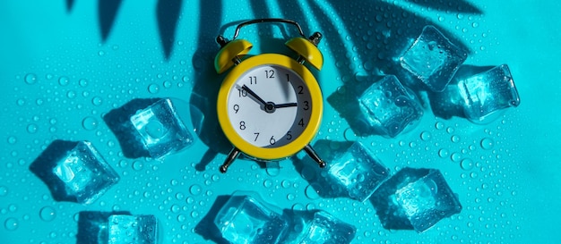 Uhr und Eiswürfel Urlaubs- und Sommerzeitkonzept Selektiver Fokus