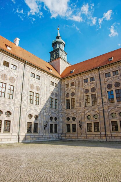 Uhrturm am Schloss in München vor blauem Himmel bei schönem Wetter