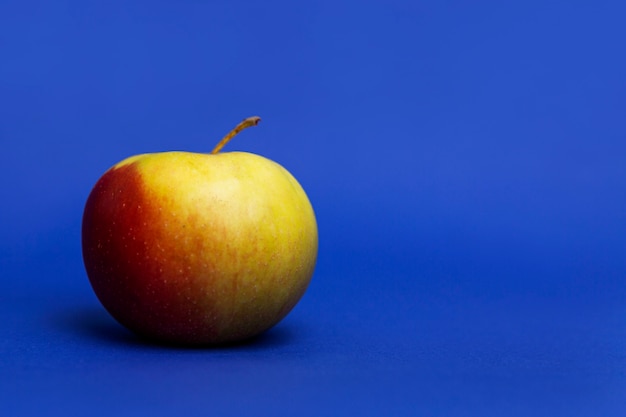 Uicy roter Apfel. Blauer Hintergrund. Gesunde Ernährung und vegane Ernährung. Nahansicht.