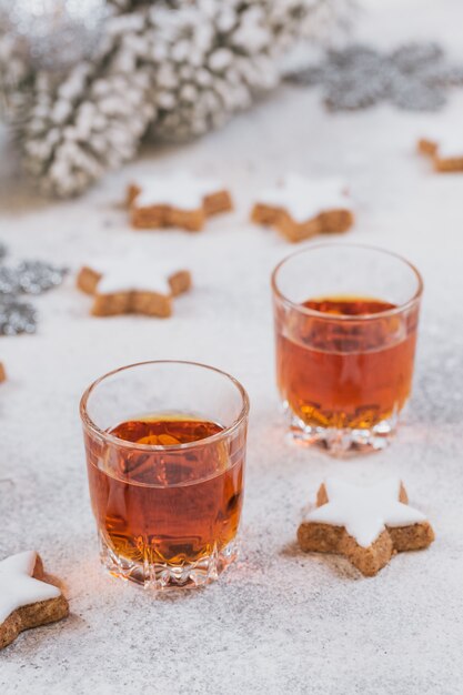 Uísque, conhaque ou licor, biscoitos e decorações do feriado de inverno em fundo branco. Conceito de férias sazonais.