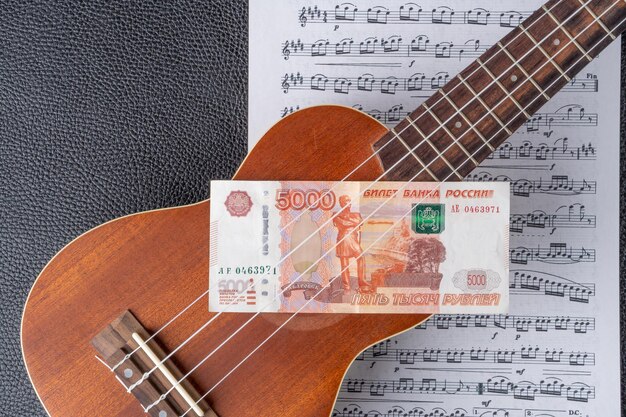 Un ukelele con un billete de 100 rublos