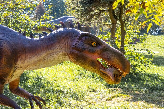 Foto ukraine, chmelnizki, oktober 2021. modell eines baryonyx-dinosauriers mit fisch im maul im park bei sonnigem wetter