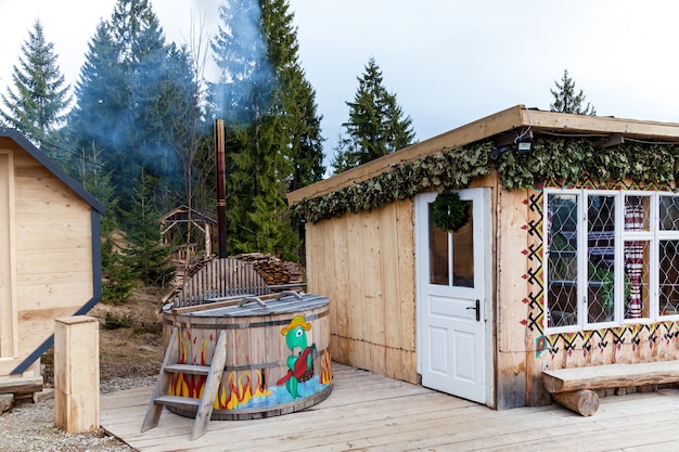 Ukraine Kamenetz 02. August 2019: Ein kleines Holzhaus mit rotem Dach befindet sich zwischen grünen Bäumen im Wald.